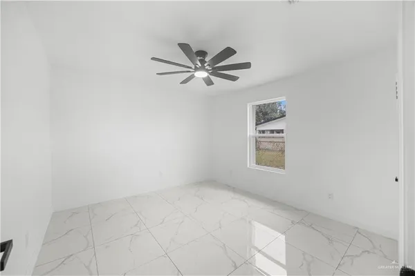 an empty room with a window and a ceiling fan