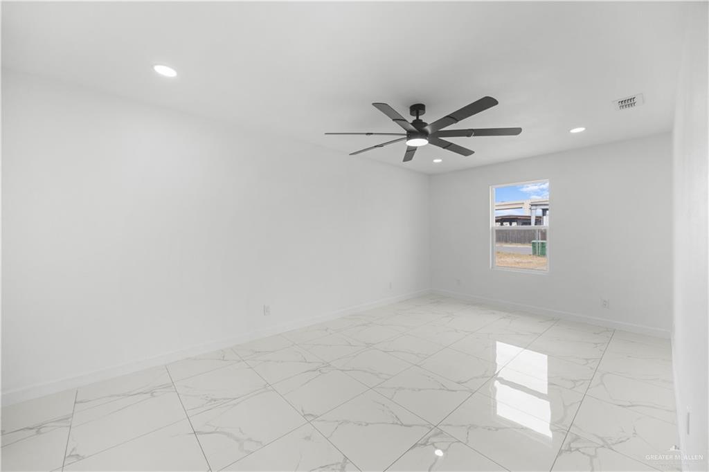313 West Eller Avenue Pharr, TX 78577 - Photo 10 of 15 an empty room with chandelier fan and windows
