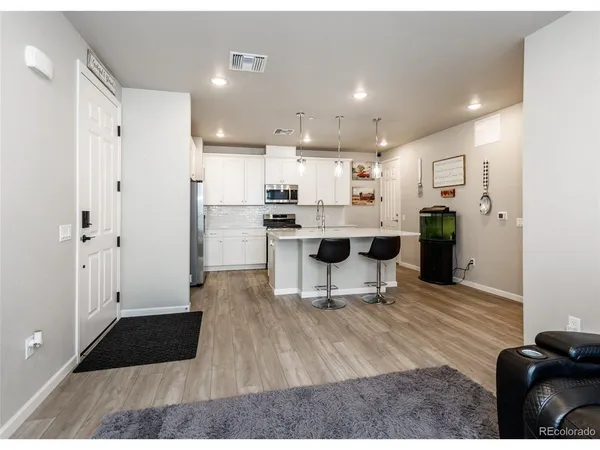 a living room with stainless steel appliances kitchen island granite countertop furniture and a view of kitchen