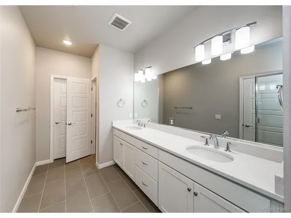a bathroom with a double vanity sink mirror and double
