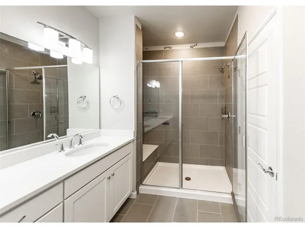 a bathroom with a shower sink and mirror