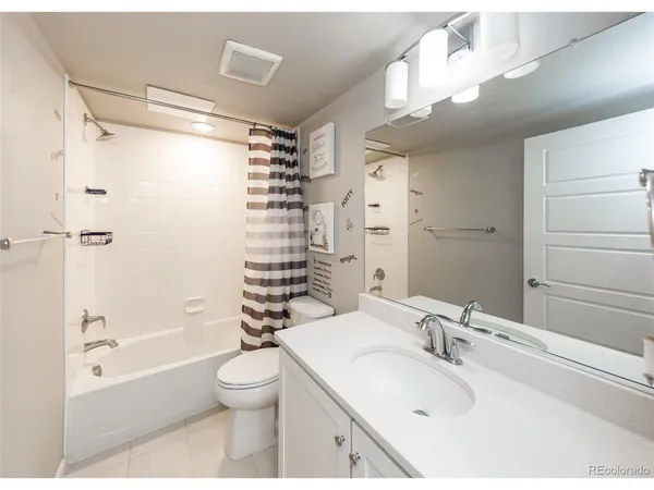 a bathroom with a granite countertop sink a toilet and shower