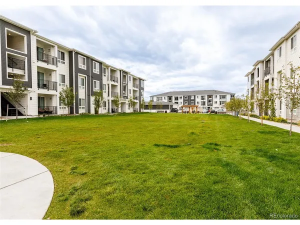 a view of a patio with table and chairs potted plants and a big yard
