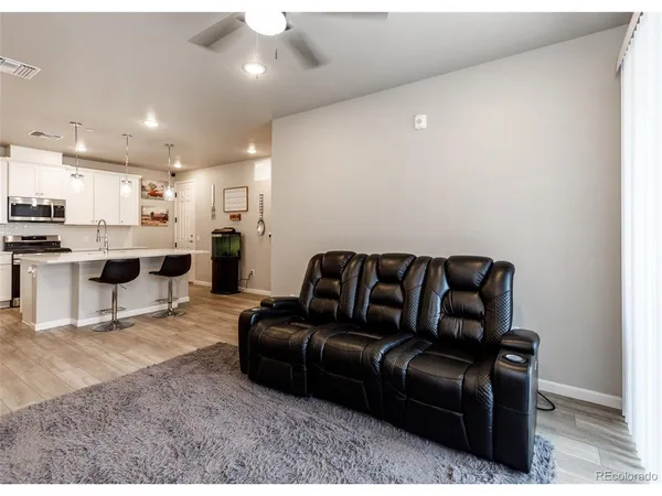 a living room with stainless steel appliances kitchen island granite countertop furniture and a view of kitchen