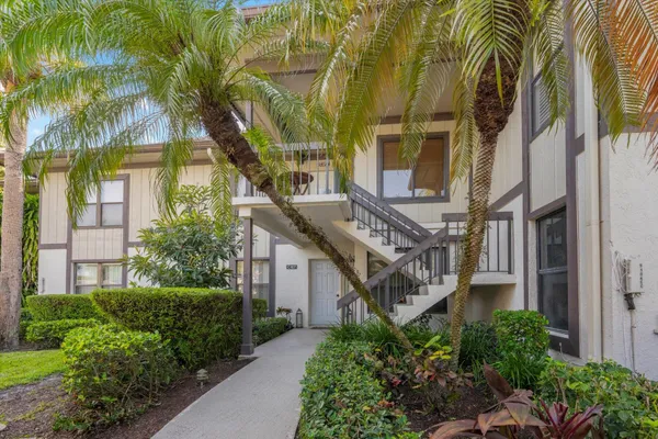 a view of a house with a yard and potted plants
