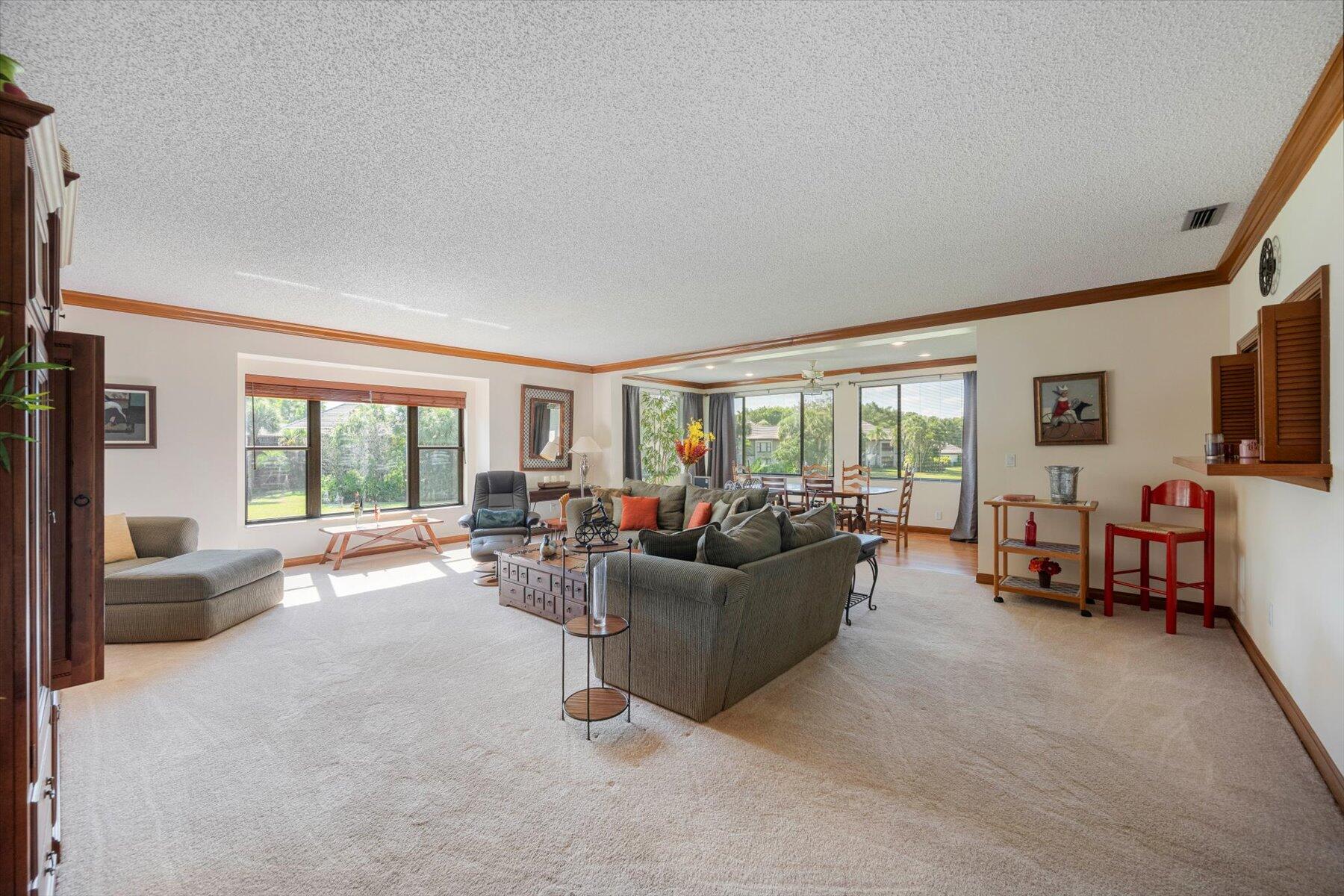 13244 Polo Club Road, Unit C207 Wellington, FL 33414 - Photo 28 of 31 a living room with furniture and a flat screen tv