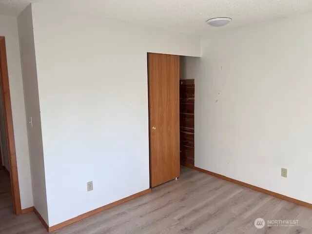 an empty room with wooden floor and closet