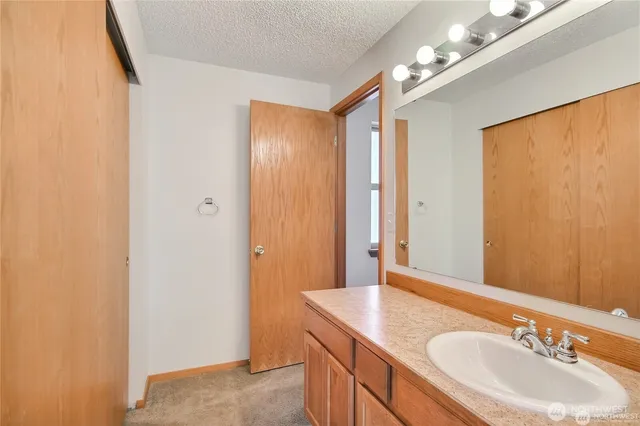 a bathroom with a granite countertop sink a mirror and a vanity