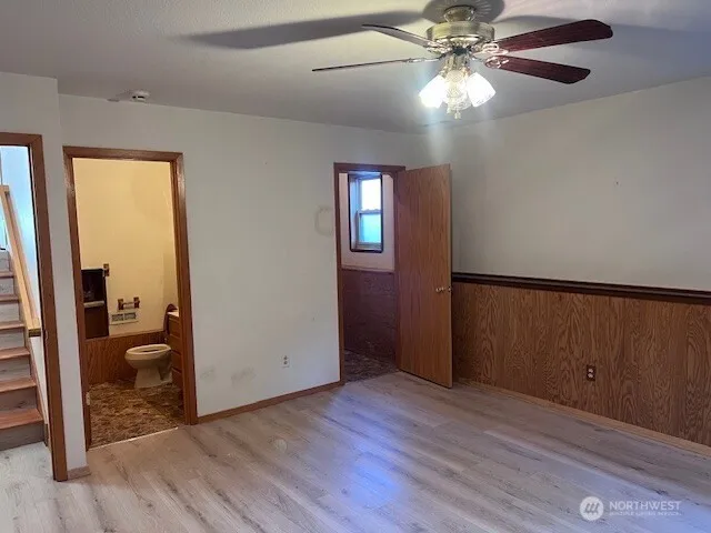 wooden floor in an empty room with a bathroom