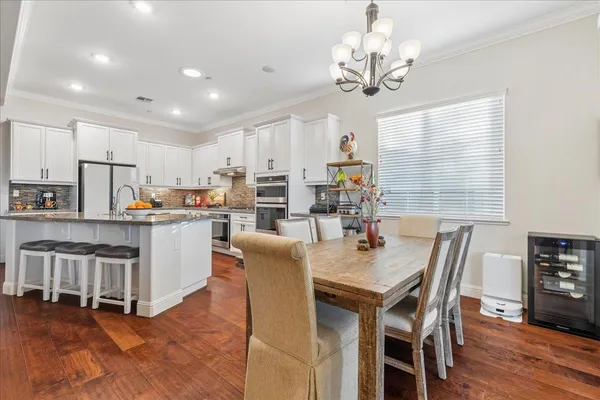 a open dining room with kitchen island stainless steel appliances furniture a chandelier open kitchen view