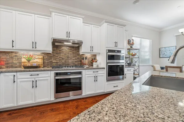 a kitchen with stainless steel appliances granite countertop a stove sink and cabinets