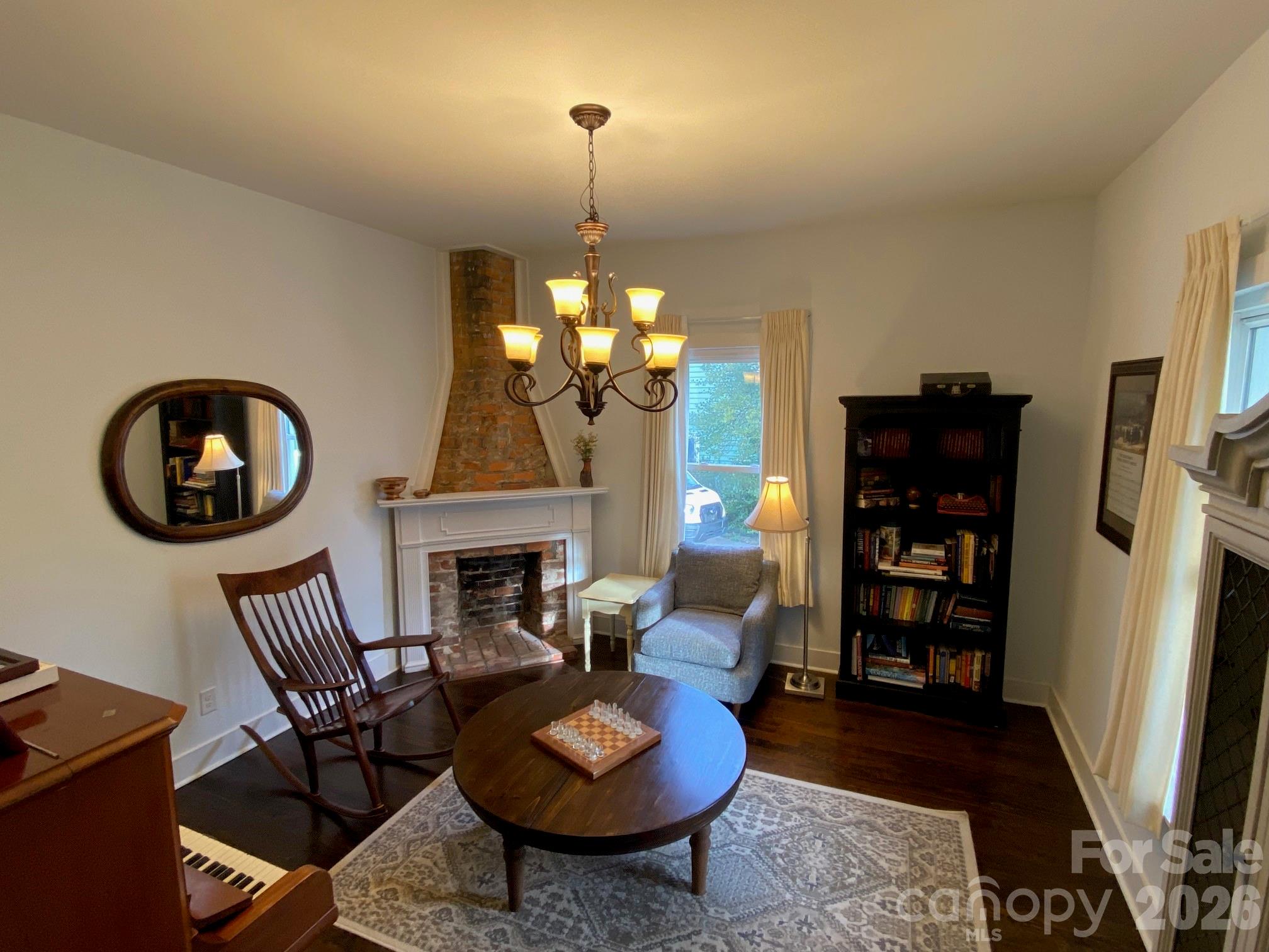 201 Main Street Matthews, NC 28105 - Photo 11 of 16 a living room with furniture a fireplace and a chandelier