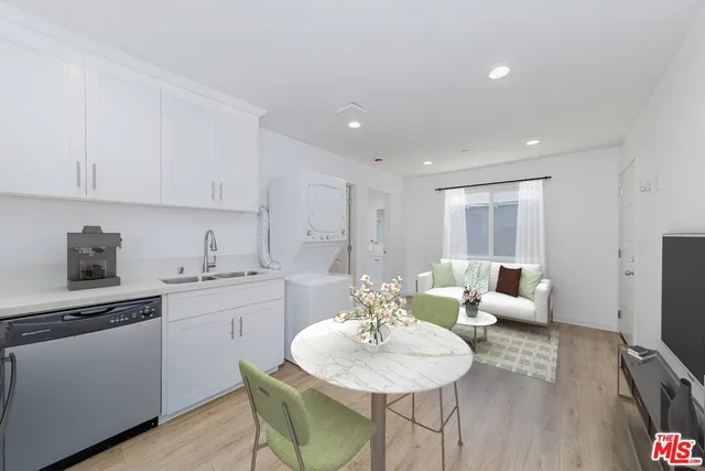 a kitchen with white cabinets and sink