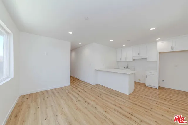 a view of a kitchen with wooden floor and a sink