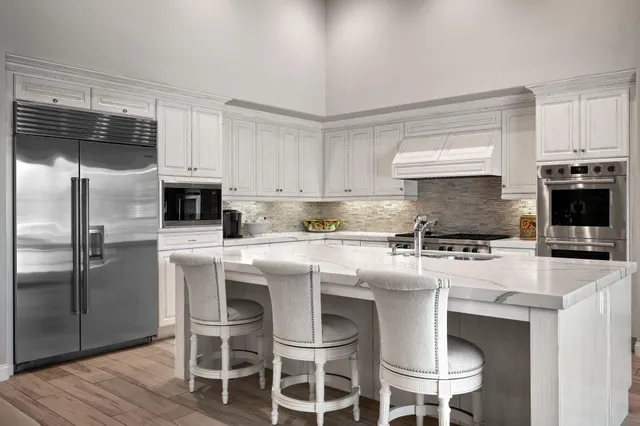 a utility room with stainless steel appliances granite countertop a sink and cabinets