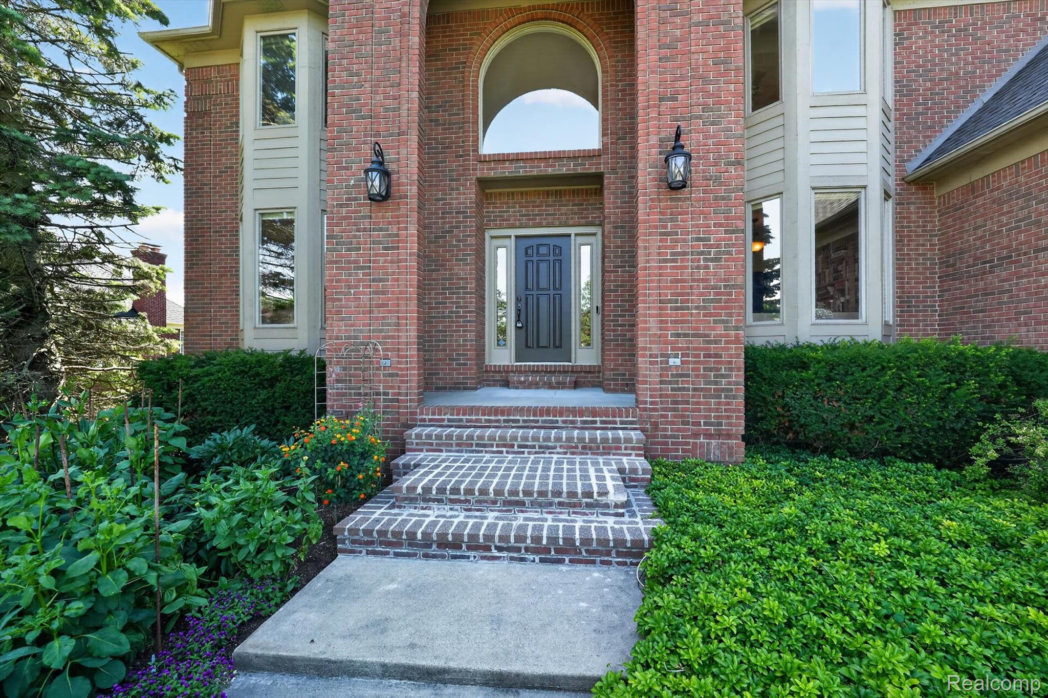 3804 Elk Drive Rochester, MI 48306 - Photo 5 of 75 Brick facade entry with a dark paneled door and sidelights