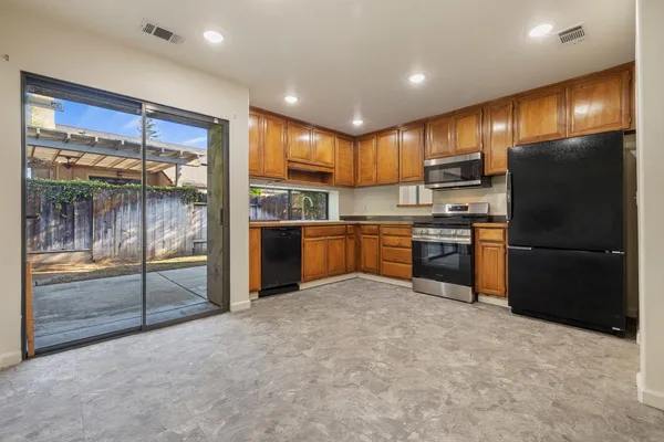 a kitchen with stainless steel appliances granite countertop a refrigerator and a sink
