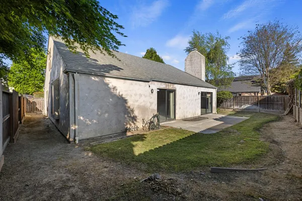 a view of a house with backyard and tree