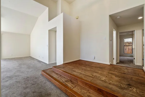 a view of a room with wooden floor and hallway