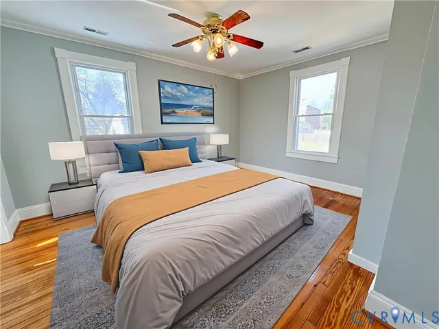 a bedroom with wooden floor and natural light
