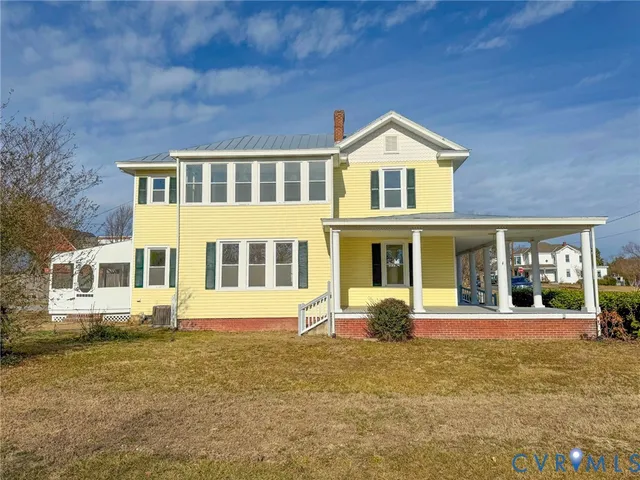 a backyard of a house with wooden fence and large tree