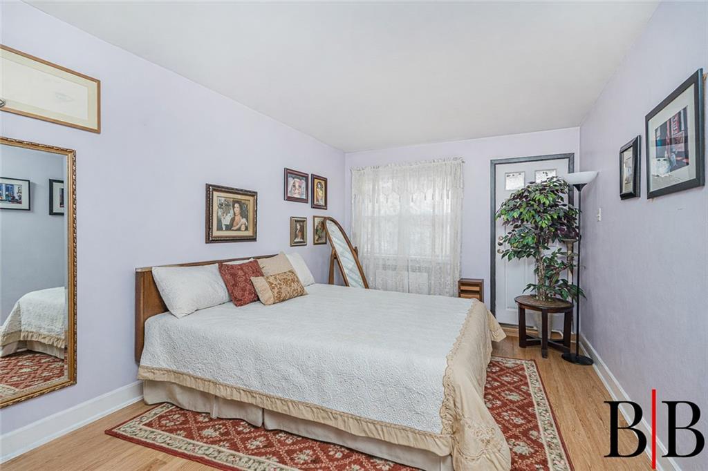 2042 Ralph Avenue Brooklyn, NY 11234 - Photo 11 of 24 a bedroom with a large bed and a potted plant