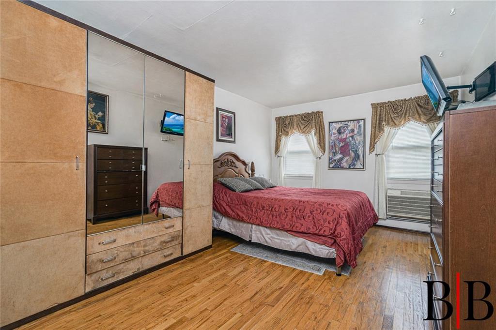 2042 Ralph Avenue Brooklyn, NY 11234 - Photo 13 of 24 a bedroom with a bed and wooden floor