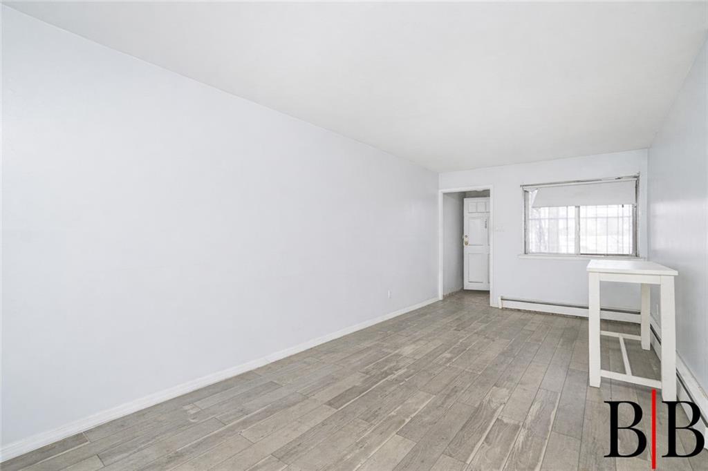 2042 Ralph Avenue Brooklyn, NY 11234 - Photo 18 of 24 an empty room with wooden floor and windows
