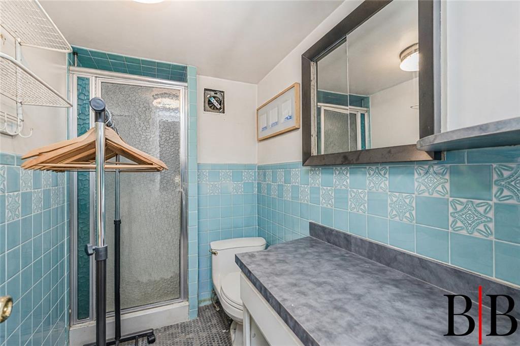 2042 Ralph Avenue Brooklyn, NY 11234 - Photo 10 of 24 a bathroom with a sink a mirror and shower