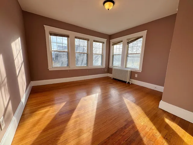 a view of room with window and wooden floor