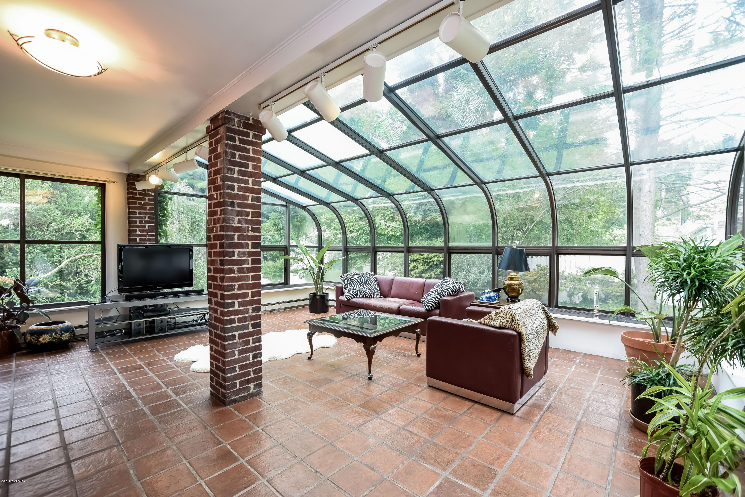12 Old Post Road Cos Cob, CT 06830 - Photo 8 of 34 a living room with furniture a flat screen tv and a floor to ceiling window
