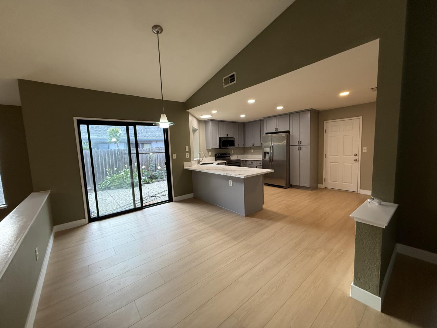 1870 Azurite Way Sacramento, CA 95833 - Photo 11 of 38 a open kitchen with stainless steel appliances granite countertop a refrigerator a sink dishwasher a stove and a dining table with wooden floor