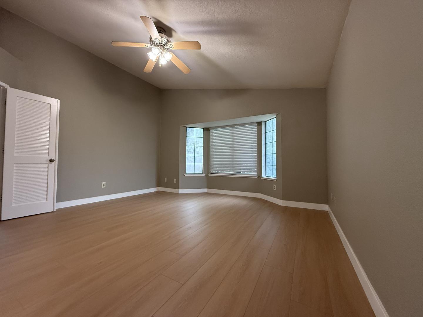 1870 Azurite Way Sacramento, CA 95833 - Photo 19 of 38 an empty room with wooden floor chandelier fan and windows
