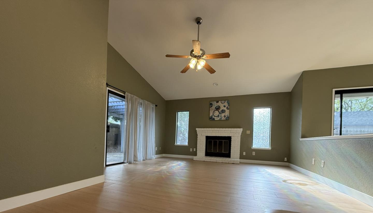 1870 Azurite Way Sacramento, CA 95833 - Photo 5 of 38 an empty room with windows a fireplace and a ceiling fan