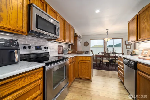 a kitchen with stainless steel appliances granite countertop a stove top oven microwave and cabinets