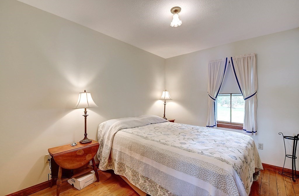 20 Old Acres Road Holland, MA 01521 - Photo 16 of 36 a bedroom with a bed and a chandelier
