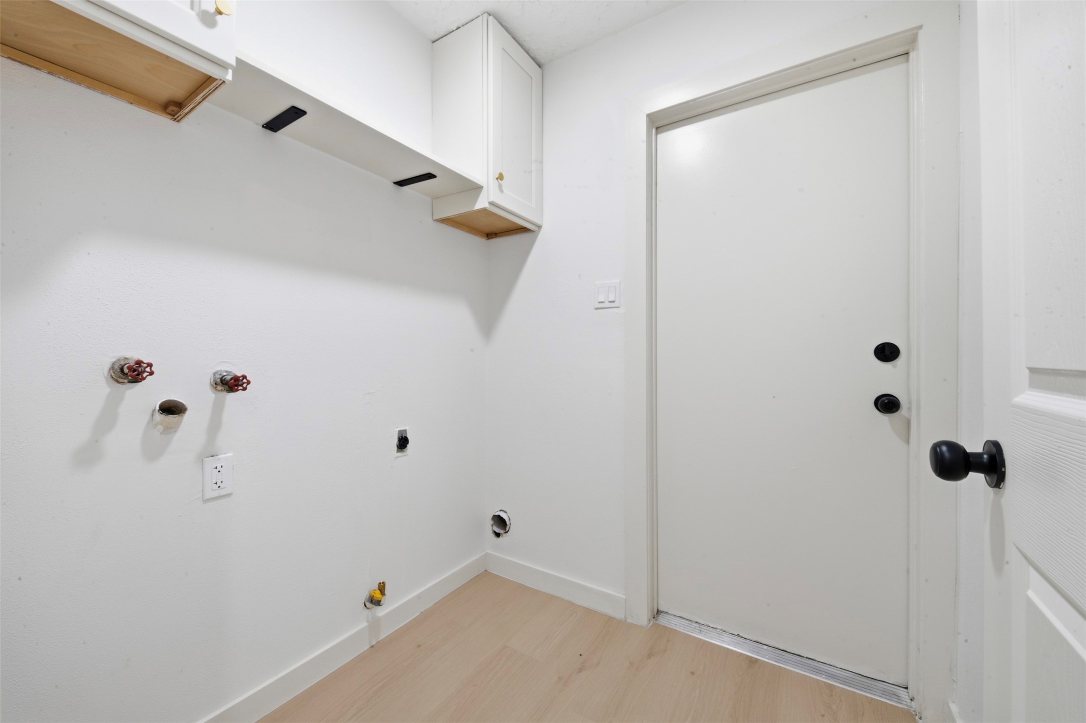 9518 Landry Boulevard Spring, TX 77379 - Photo 17 of 38 Laundry room with hookups, overhead cabinetry, and a door leading outside, offering convenience and storage.