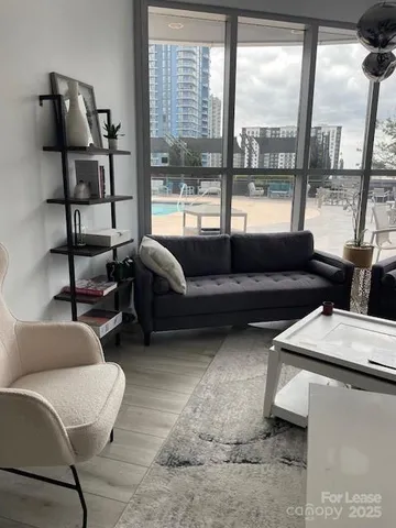a living room with furniture and a floor to ceiling window