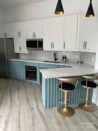 a kitchen with stainless steel appliances granite countertop a stove a sink and a refrigerator