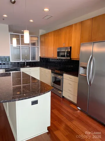 a kitchen with stainless steel appliances granite countertop a sink a stove and a refrigerator