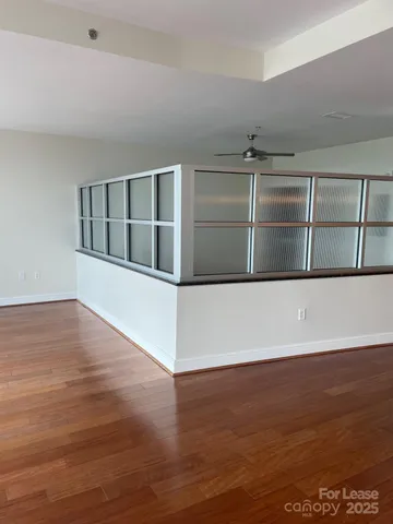 a view of an empty room with wooden floor