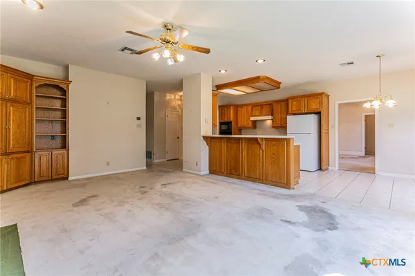 a view of an empty room with a fireplace and a window