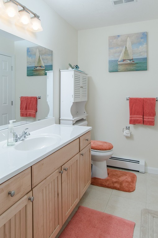 2 Sterling Lane, Unit 2 Walpole, MA 02081 - Photo 15 of 27 a bathroom with a sink a toilet and mirror