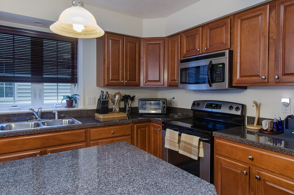 2 Sterling Lane, Unit 2 Walpole, MA 02081 - Photo 3 of 27 a kitchen with granite countertop a sink stainless steel appliances and cabinets