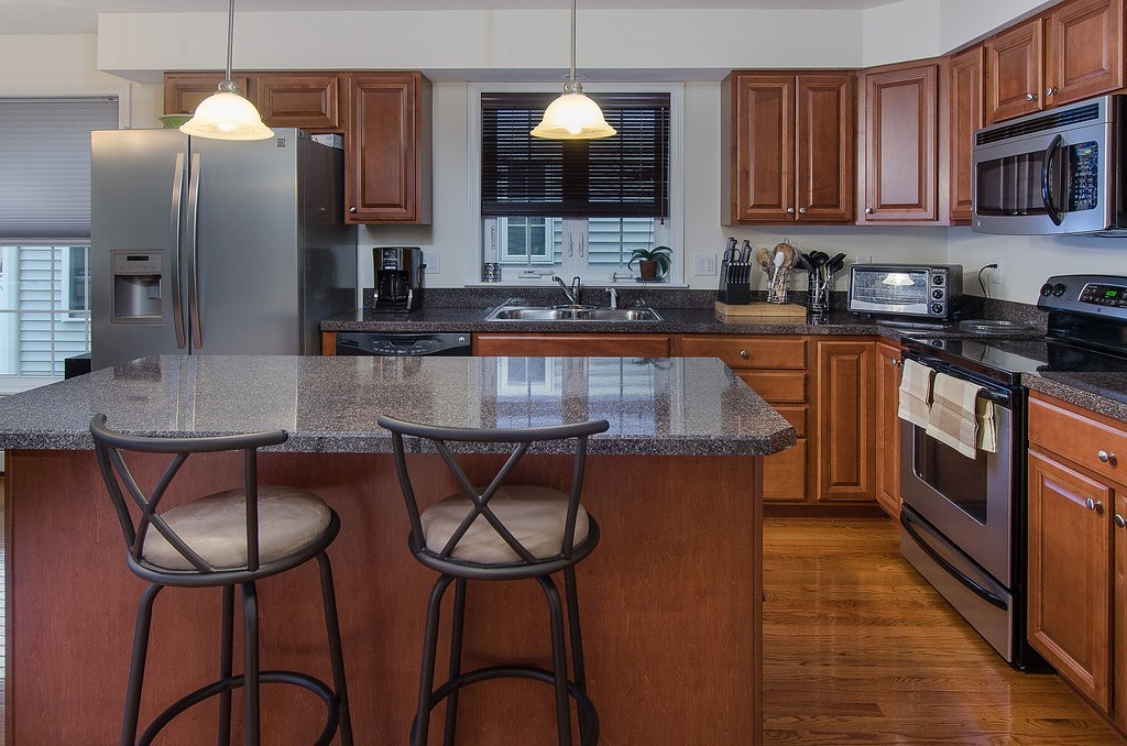 2 Sterling Lane, Unit 2 Walpole, MA 02081 - Photo 4 of 27 a kitchen with stainless steel appliances granite countertop a stove a sink dishwasher a microwave oven and a refrigerator with wooden floor