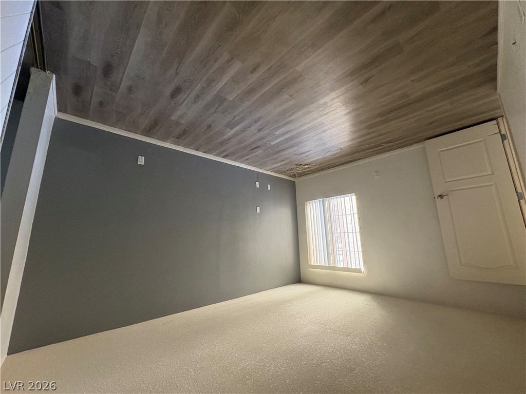 9325 West Desert Inn Road, Unit 123 Las Vegas, NV 89117 - Photo 21 of 36 A well-lit bedroom with fresh carpet and stylish wood-look flooring on the ceiling.