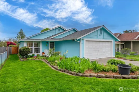 a front view of a house with a garden and plants