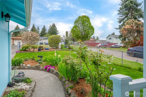 a view of a garden with a lot of flower plants and wooden fence