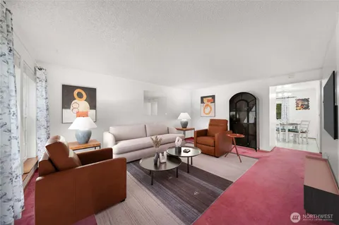 a living room with furniture a rug and white walls