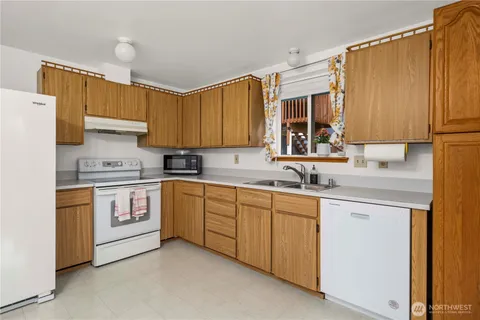 a kitchen with granite countertop a sink stainless steel appliances and cabinets